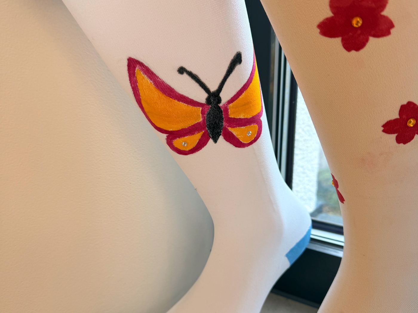 Individuell bemalte Kompressionsstrümpfe mit Schmetterling und Blüten